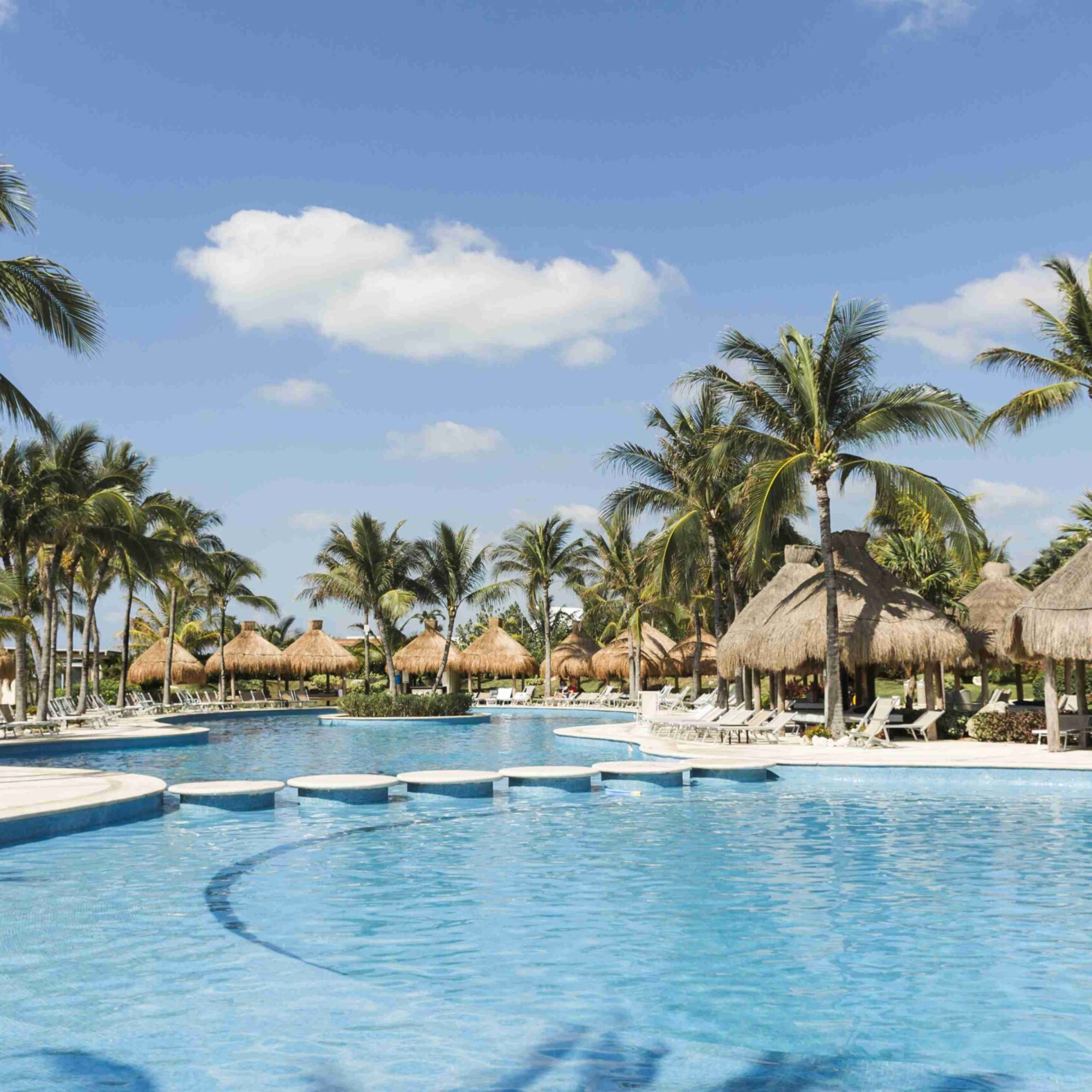 sun-loungers-near-palms-swimming-pool-sunny-day_